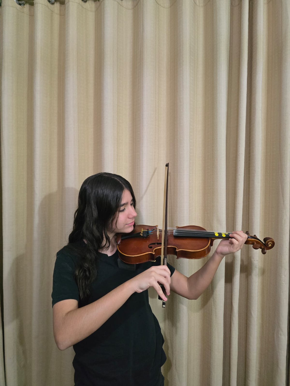 Aluna tocando violino em aula com Willian Rodrigues